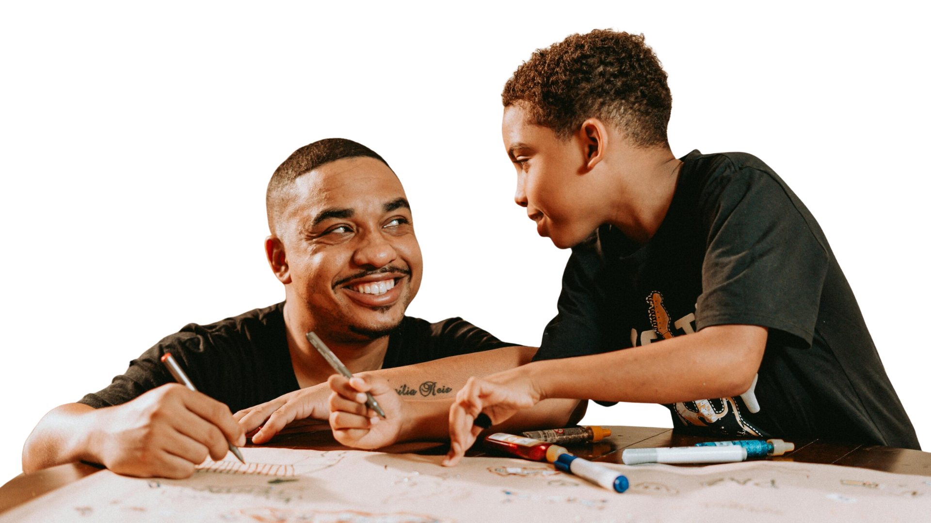 Father and son at a table writing a letter, happy